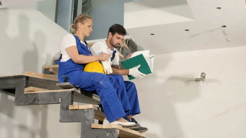 Group of construction workers watching some details on a blueprint Stock Footage 91240457