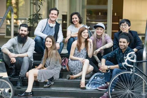 Group of creative colleagues sitting together outdoors Stock Photos