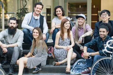 Group of creative colleagues sitting together outdoors Stock Photos
