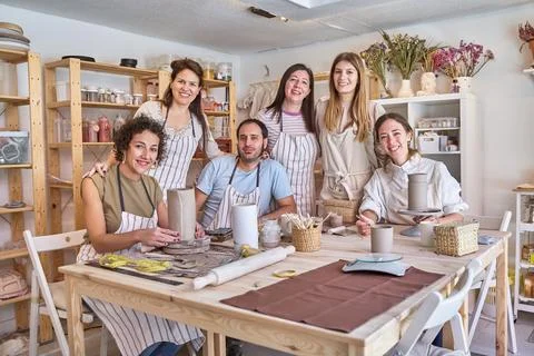 Group of creative people posing together while having fun in a pottery class. Fotos Stock