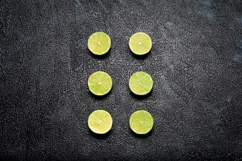 Group of cut limes on dark background Stock Photos