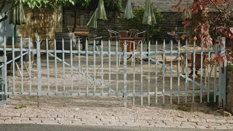 Group of Cyclists Passing Blue Iron Gate of Cafe - Chateau-Chalon, France 库存影片 344449213