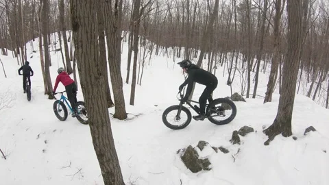 Group of cyclists riding fatbikes in the winter on a groomed trail Stock Footage 231424643