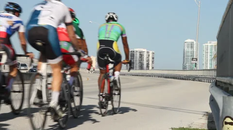 Group of cyclists, sharing road with car traffic , city skyline in back ground Stock Footage 36640282