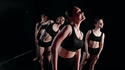 A group of dancers dances an abstract movement in the dark in slow motion Видео 159584388