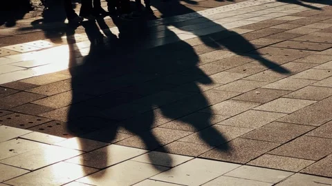 Group of demonstration people gathering with heir long shadows casting on a p Stock Footage 277651261