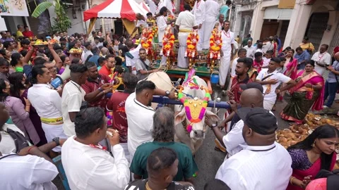 A group of devotees are gathered around a decorated chariot during Thaipusam Видео 318102296