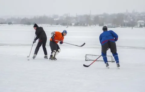 Group of different aged people playing hokey on a frozen river Dnipro Stock-Fotos