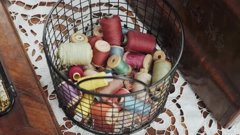 A group of different colours spools of thread in a basket Stock Footage 221710189
