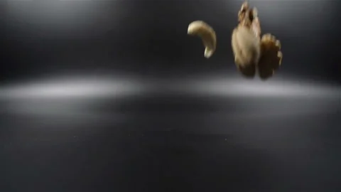Group of different nuts falling in slow motion on black background Video stock 104597012