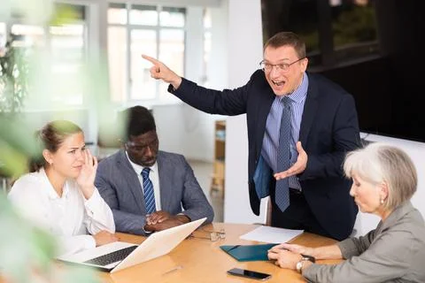 Group of different people arguing at table in office Stock-Fotos