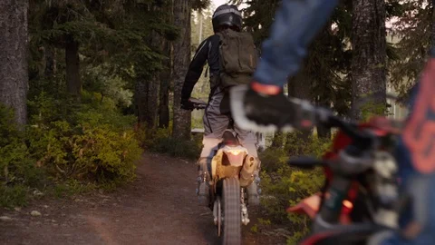 A group of dirt bikers pull up to a mountain lake Stock Footage 93002696