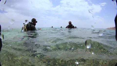 A group of divers begins their dive. The camera shoots under and over water Stock Footage 132255318