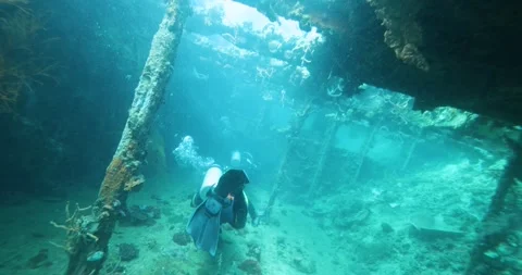 A group of divers diving towards a sunken ship in the Philippine Sea Stock Footage 268040233
