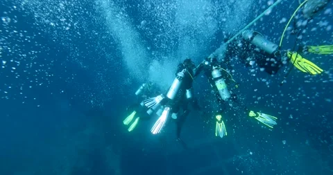 A group of divers diving towards a sunken ship SS Thistlegorm in the Red Sea Stock Footage 281619939