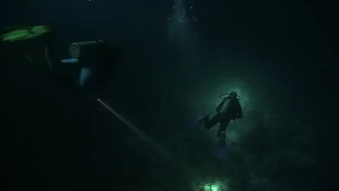 Group of divers embarks on impressive night dive on coral reef. Stock Footage 260841084