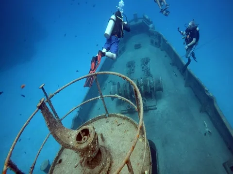 Group of Divers Swim Outside Sunken Ship Stock Footage 75799098