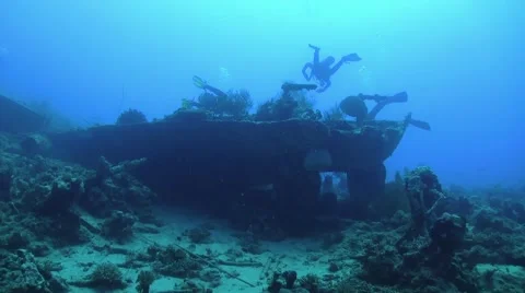Group of Divers Swims over Ship Wreck Stock Footage 51770192