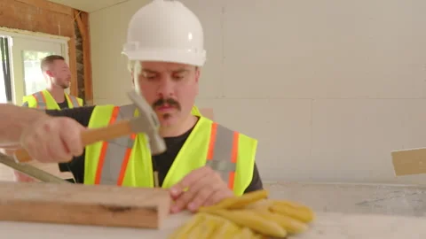 A group of diverse builders is collaborating together on a challenging house Stock Footage 305796874