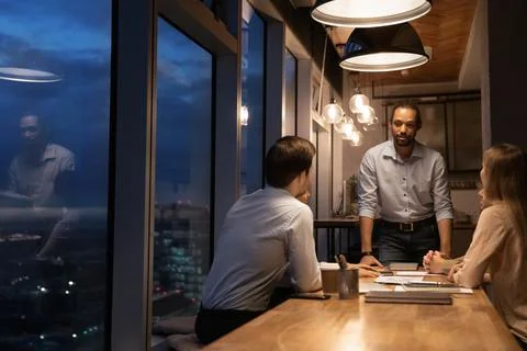 Group of diverse colleagues working until late in modern office Foto stock
