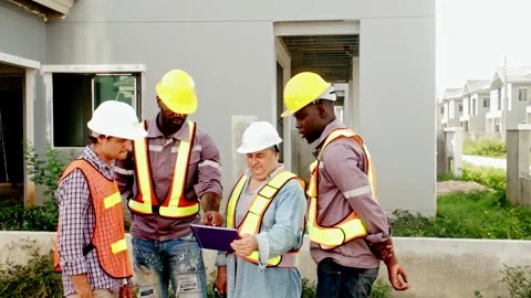 Group of diverse construction workers and site manager reviewing plans outdoors. Video stock 309509135