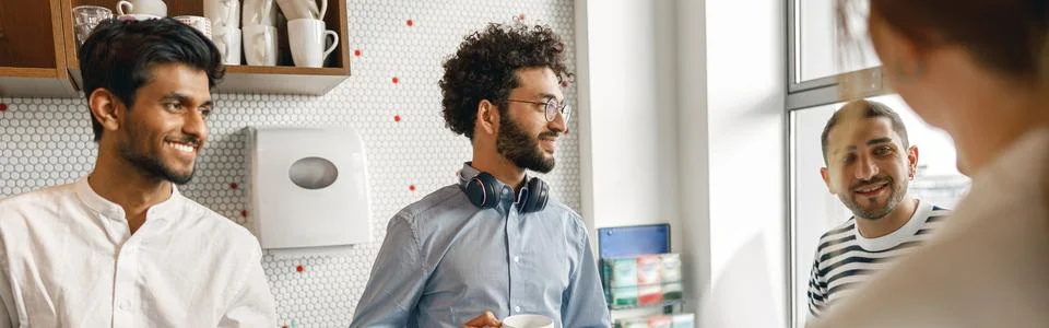 Group of diverse coworkers drink coffee during break and talking about work Stock Photos
