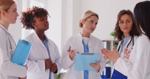 Group of diverse female doctors standing in medical office, discussing patient Stock Footage 311282102