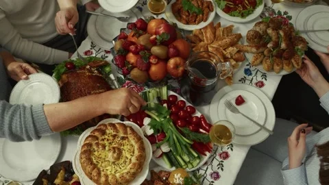 Group of diverse hands reaching for a festive table filled with various Stock Footage 332736952