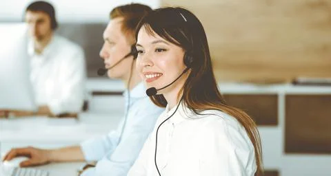Group of diverse operators at work in call center. Beautiful asian woman sitting Stock Photos