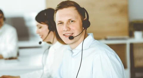 Group of diverse operators at work in call center. Businessman sitting n headset Stock Photos
