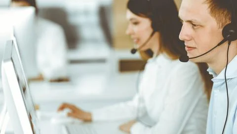 Group of diverse operators at work in call center. Businessman sitting n headset Stock Photos
