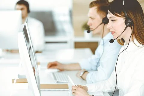 Group of diverse operators at work in call center. Beautiful asian woman sitting Stock Photos