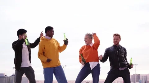 Group of diverse people dancing playfulness outdoors drinking beer and having Stock Footage 248367140