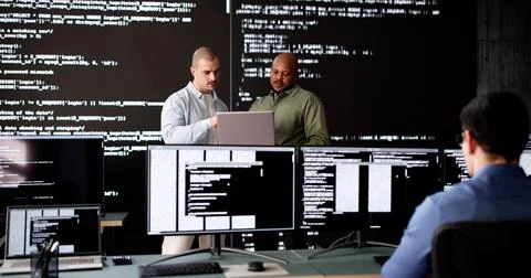 Group of diverse software engineers coding on computers Stock Photos