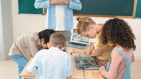 Group of diverse student working together while teacher hold tablet. Pedagogy. Stock-Fotos