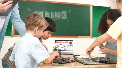 Group of diverse student working together while teacher hold tablet. Pedagogy. Stock Photos