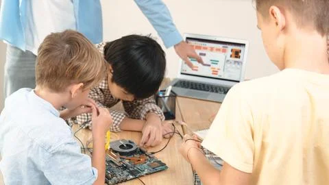 Group of diverse student working together while teacher hold tablet. Pedagogy. Stock Photos