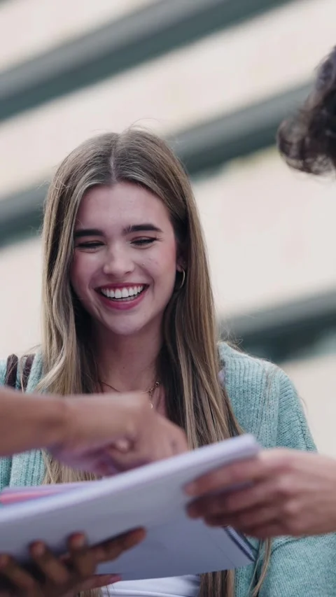 Group of diverse university students studying together outdoors. Vertical Stock Footage 337417092