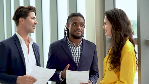 Group of diversity business people standing talking and working with paper .. Stock Footage 254889448