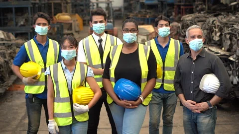 Group of diversity Workers wear protective face mask holding hard hat Stand i Stock Footage 153572097