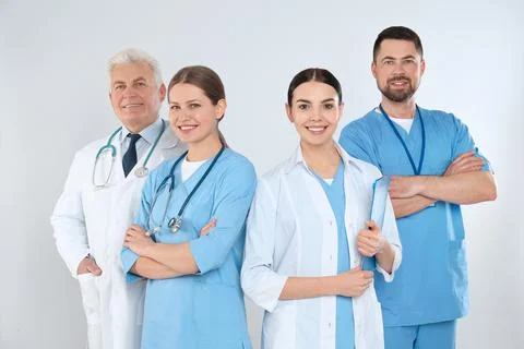 Group of doctors against light background. Medical service Stock Photos