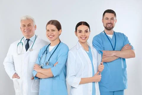 Group of doctors against light background. Medical service Stock Photos