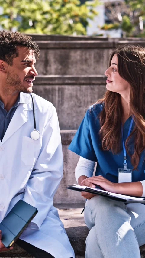 Group of doctors and nurses having a conversation outdoors Stock Footage 343675595