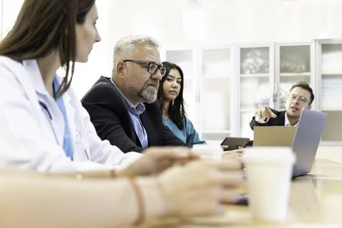 Group of doctors and nurses working together in a conference room at hospital Stock Photos