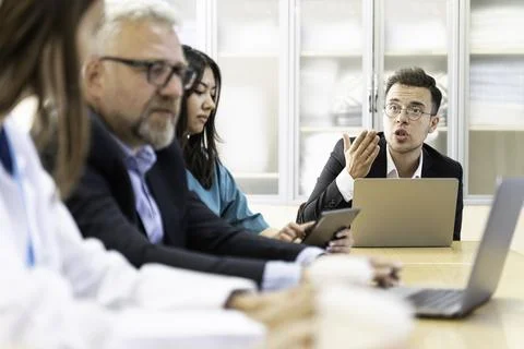 Group of doctors and nurses working together in a conference room at hospital Stock Photos