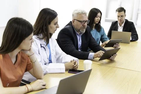 Group of doctors and nurses working together in a conference room at hospital Stock Photos