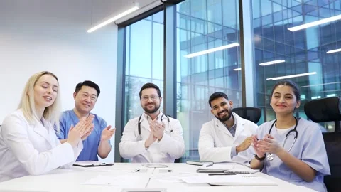 Group of doctors applauding look at camera sitting in a hospital office  库存影片 319069697