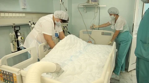 A group of doctors connect the device to heat the patient after the operation. Stock Footage 94768360