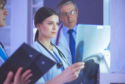 Group of doctors examining x-rays in a clinic, thinking of a diagnosis Stock Photos