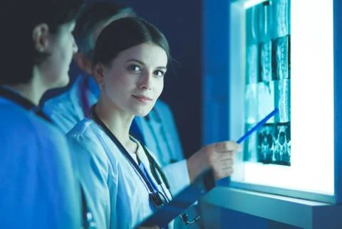 Group of doctors examining x-rays in a clinic, thinking of a diagnosis Stock Photos
